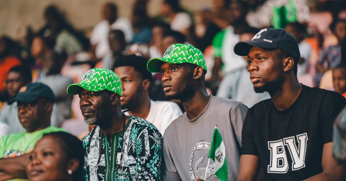 Capturing Nigerian football fans in vibrant green attire, showcasing cultural pride and excitement.