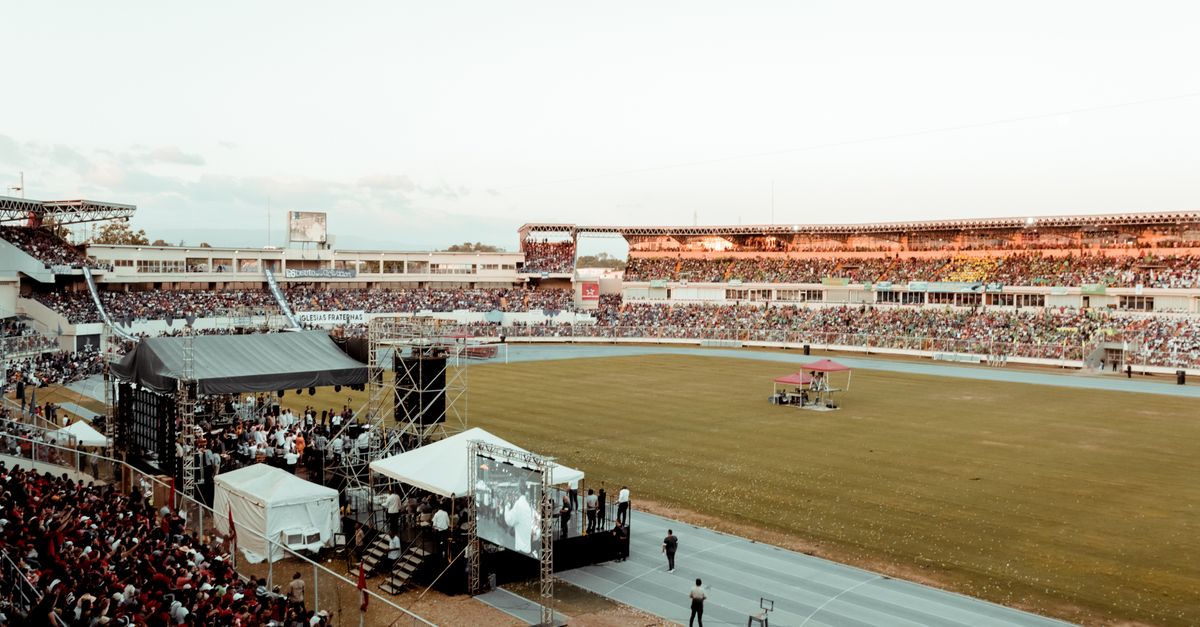 A lively crowd gathers at a football stadium during an outdoor event, showcasing spectator excitement.